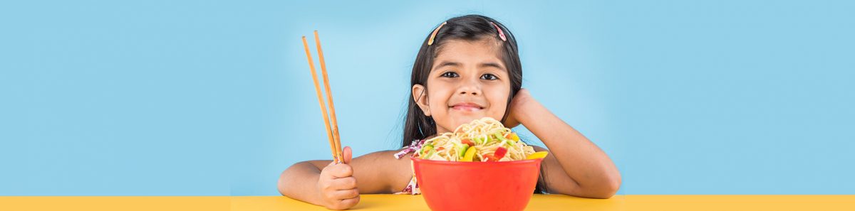Child with noodles and vegetable bowl with chopsticks